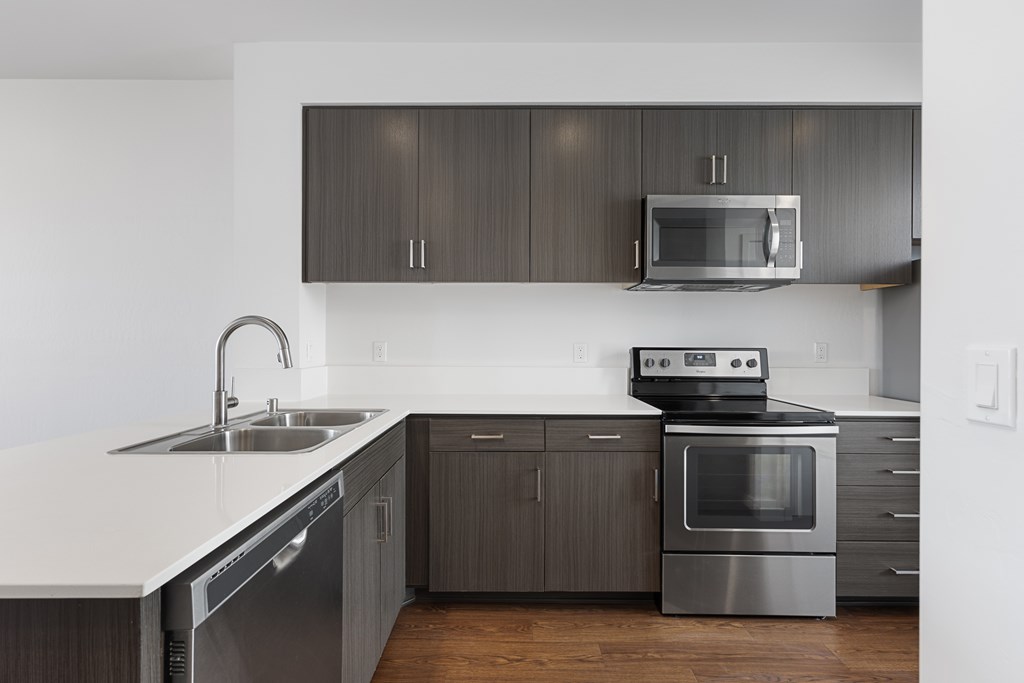 A modern kitchen with a stainless steel oven and microwave.